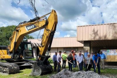 Picture of heavy equipment and people with shovels for ceremonial ground breaking.